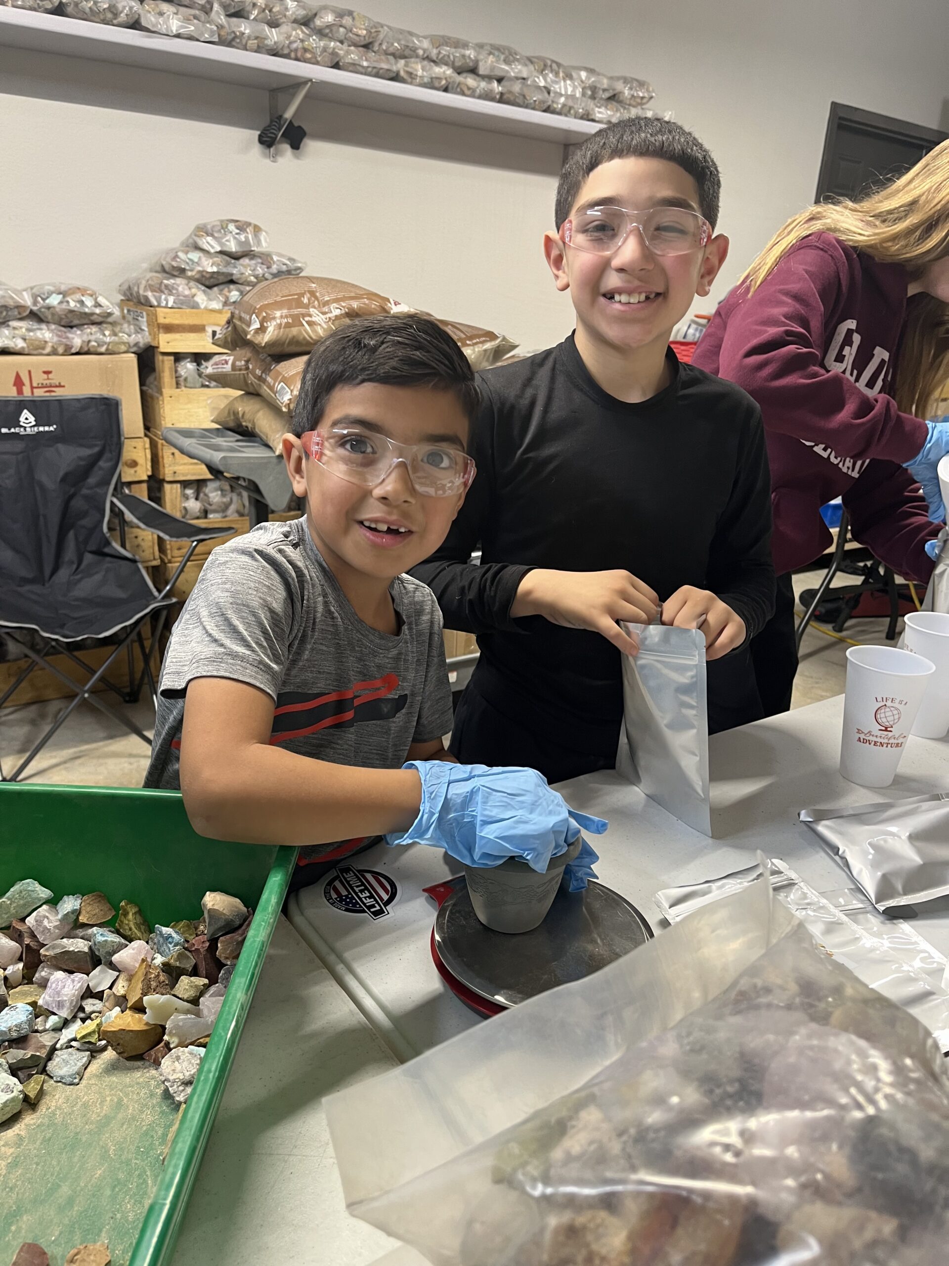 Youth volunteers assembling Christmas mineral kits at a worktable